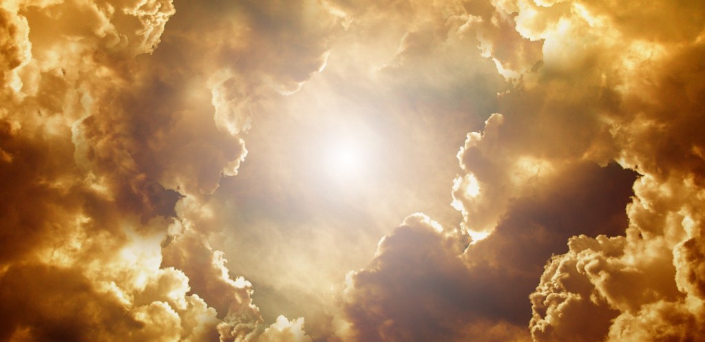 Poetry clouds lit in gold, copper and deep browns surrounding the sun