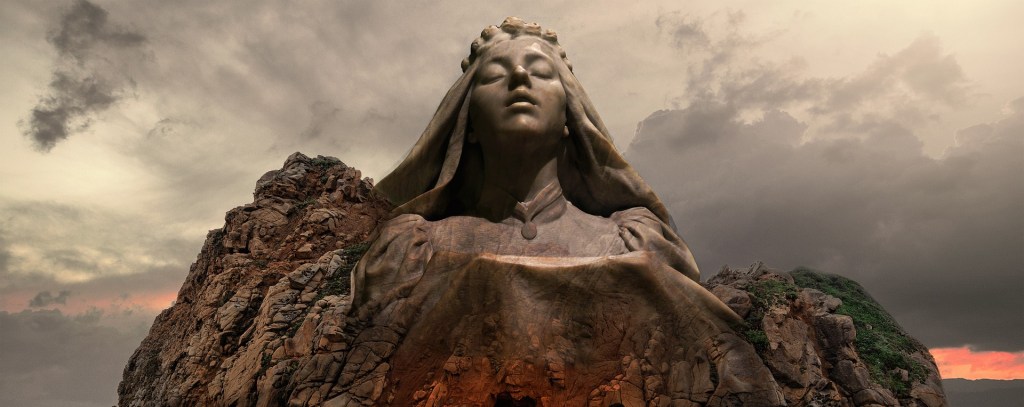 Poetry A stone goddess rising from the outcropping of a a rock jutting out from the Earth in a backdrop of greying skies