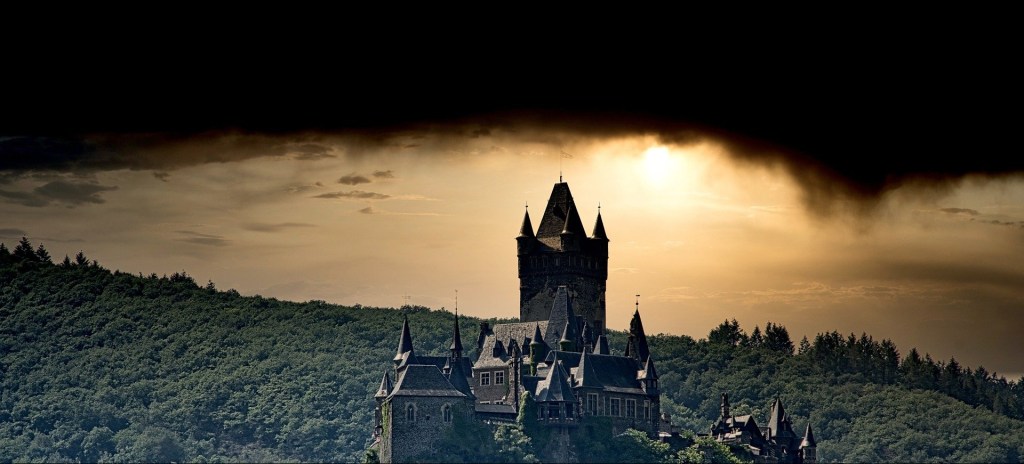 Poetry a castle on a mountain top of trees, the sky blackened with storm clouds with a diffusing sun