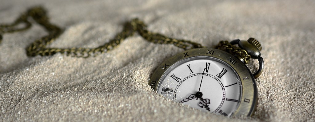 Poetry a pocket watch half submerged in sands